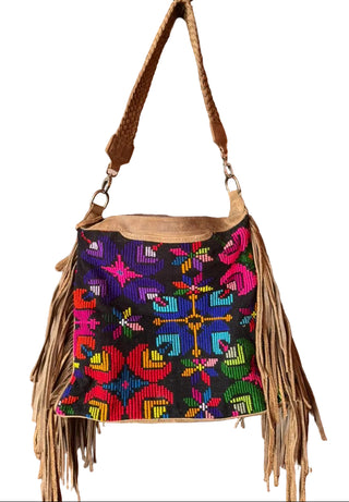 Colorful handbag with fringe hanging on a wooden door