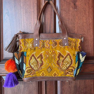 Handbag with colorful pattern and tassels on a wooden door