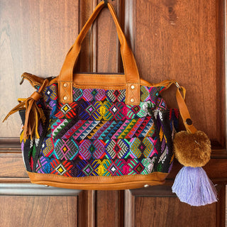 Colorful handbag with intricate patterns hanging on a wooden door