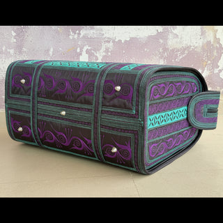 Patterned toiletry bag on a light wooden surface