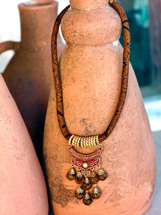Necklace with decorative pendant on a terracotta pot