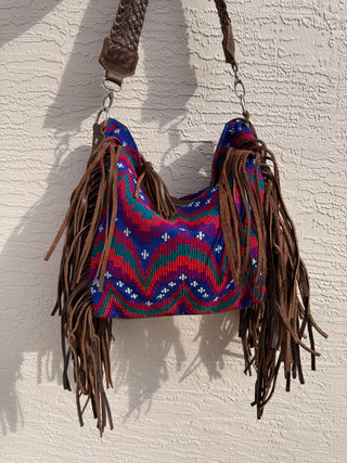 Colorful bag with fringes on a textured white background