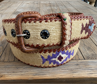 Woven belt with a decorative buckle on a wooden surface
