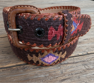 Decorative belt with intricate patterns on a wooden surface