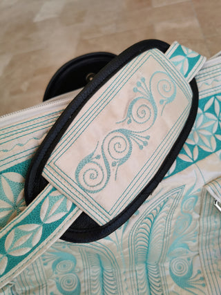 Close-up of a patterned strap with decorative elements on a textured surface